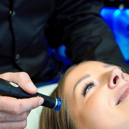 Dermatologist MUDr. Martin Bortlík treating a patient’s cheek area with a HydraFacial device.
