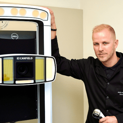 Dermatologist MUDr. Martin Bortlík from Skinity Clinic standing next to the IntelliStudio by Canfield device used for mole analysis and screening.