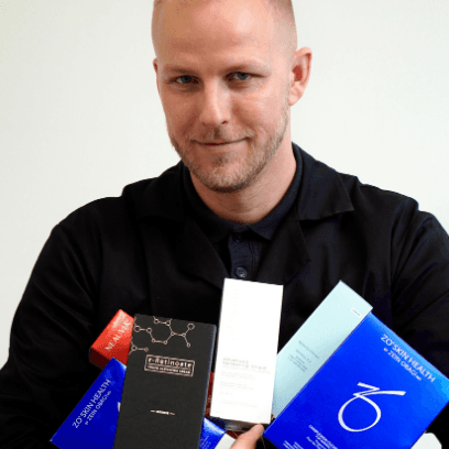 Dermatologist MUDr. Martin Bortlík holding various skincare products from the ZO Skin Health brand and other dermatological cosmetics.