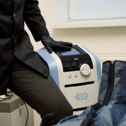 Dermatologist MUDr. Martin Bortlík resting his hand on the Lymphastim device, designed for lymphatic drainage therapy to improve circulation and remove excess fluids from the body.