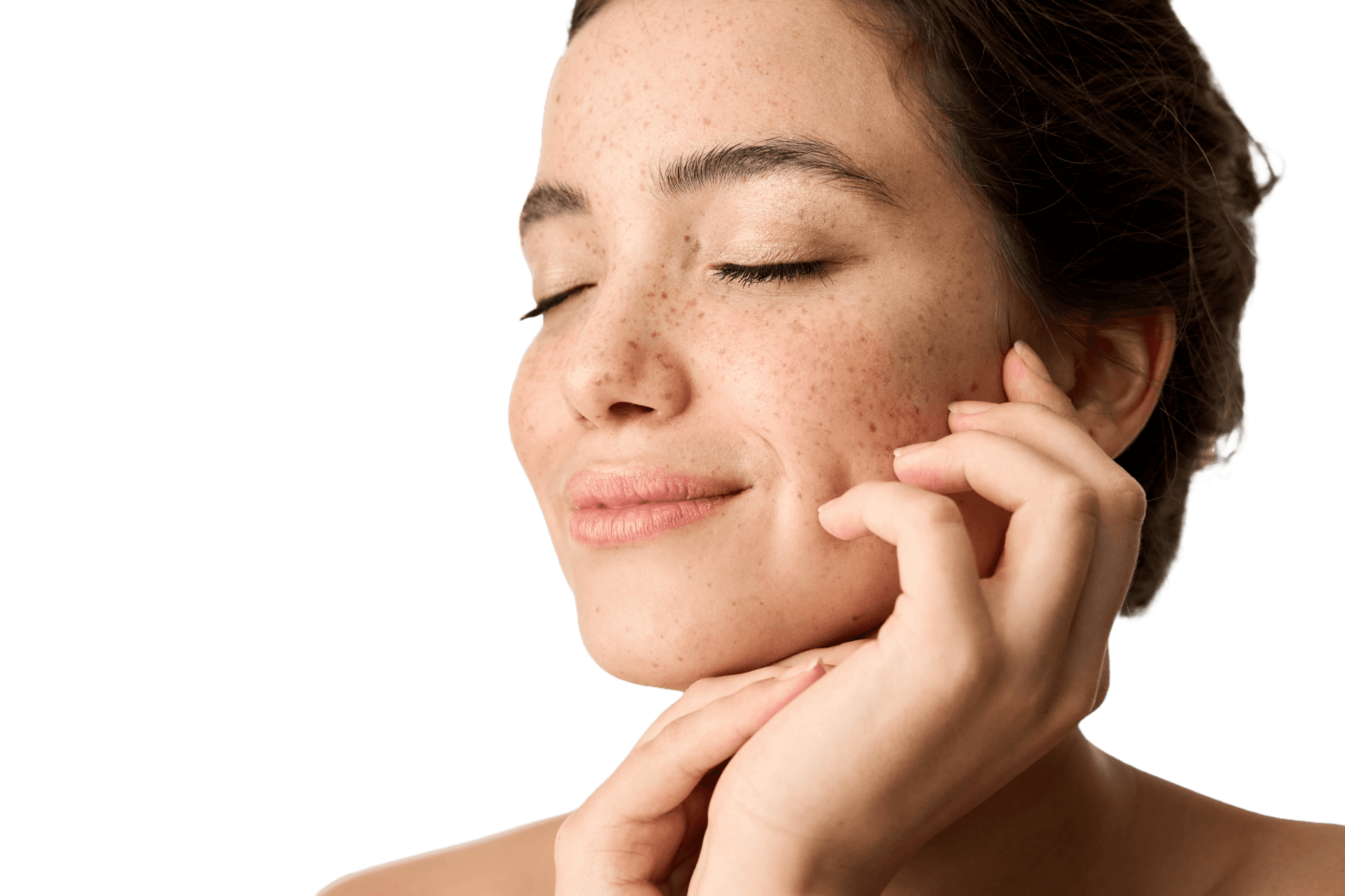 Portrait of a young woman with freckles and closed eyes – she smiles softly and touches her face. The image conveys calmness and natural beauty, illuminated by soft light.