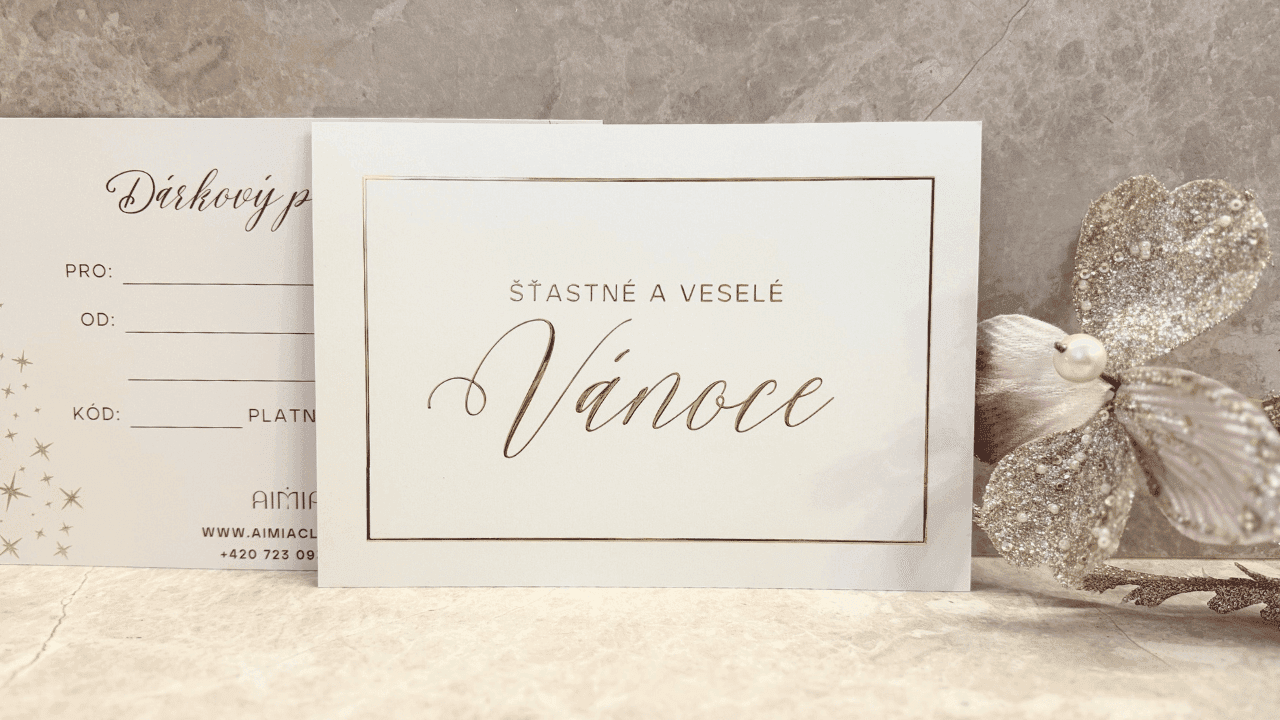 Christmas gift voucher from Skinity Clinic placed on a light surface. The voucher bears the gold inscription “Merry Christmas” and is decorated with a gold and pink glittering flower.